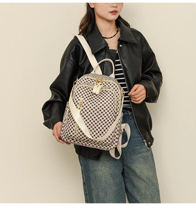Detail of vintage patterned backpack showing faux leather straps and golden zipper