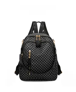 Front view of black backpack with geometric print and luxury gold zippers and hardware