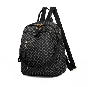Close-up of black printed backpack with silver geometric dots and gold metal zippers