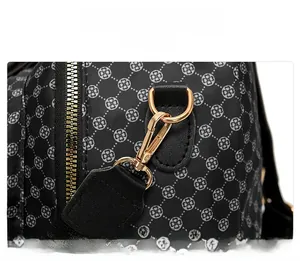 Close-up of golden metal zipper and detachable swivel hook on floral patterned backpack
