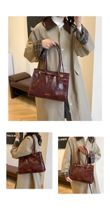Detailansicht der weinroten Ledertasche mit glänzender Textur und Metallschnallen am Gurt