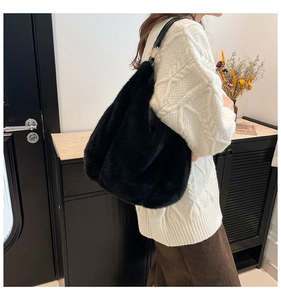Detail of black faux fur shoulder bag with leather strap and gold metal hardware