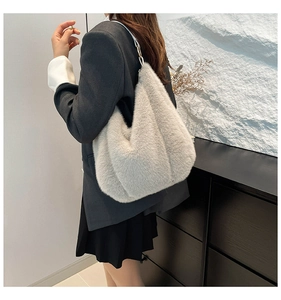 Detail of soft plush faux fur tote bag with metal chain strap worn on shoulder