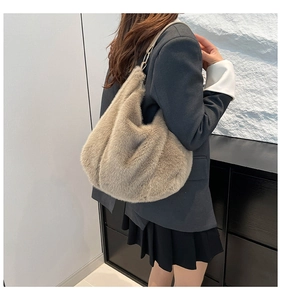 Close-up of fluffy faux fur tote bag in light khaki worn by model with leather strap