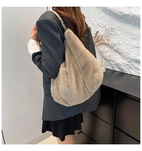 Detail of light brown faux fur hobo bag with a leather strap and metal ring hardware