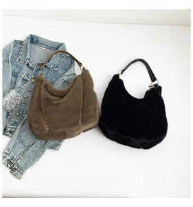Detail of plush faux fur shoulder bags in brown and black with leather handles
