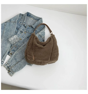 Detail of dark brown plush hobo bag with leather handle and metal rings for autumn