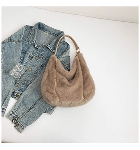 Detail of khaki faux fur hobo bag with smooth leather strap and gold metal hardware