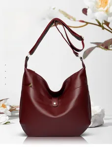 Detailed macro view of wine red large capacity soft leather tote bag with gold metal buckle