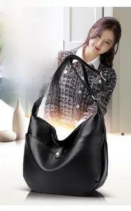 Detail of black lychee grain leather hobo bag with adjustable strap and side pocket