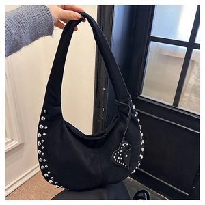 Detail of black crescent hobo bag with silver studs and heart-shaped pendant