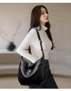 Detail of black pebbled leather hobo bag with gold hardware and soft texture