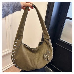 Detail of olive green suede hobo bag featuring silver rivets and heart-shaped charm