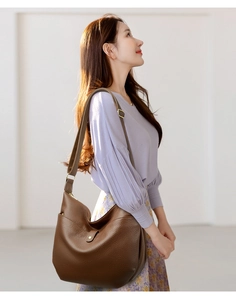 Detail view of dark brown litchi grain leather shoulder bag with adjustable strap