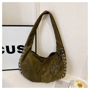 Detail of olive green suede hobo bag with silver studs and heart-shaped pendant charm
