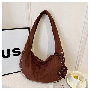 Detail of suede hobo bag with silver studs and heart-shaped charm in dark brown