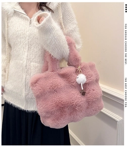 Detailed close-up of a soft pink plush bucket bag featuring a white faux fur pompom charm