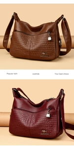 Detail view of large capacity shoulder bag with crocodile texture and metal kangaroo logo