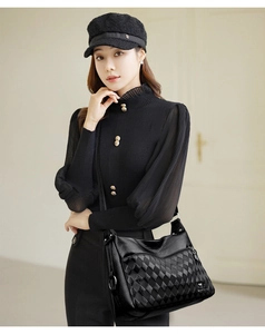 On-body view of a black crossbody bag with litchi and quilted faux leather textures