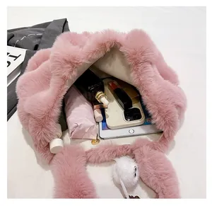 Detail showing the large capacity and magnetic closure of the pink plush bucket bag