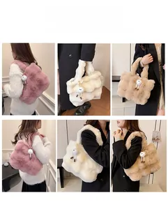 Detail of plush faux fur bucket bag with quilted texture and cute pom-pom charm accessory