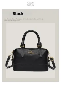 Front view of black Boston handbag with gold kangaroo emblem and metal hardware accents