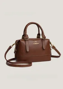 Detail of dark brown leather Boston bag with gold kangaroo emblem and fine white stitching