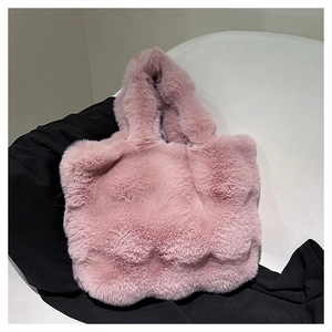Close-up of the thick faux rabbit fur texture on a soft pink plush bucket tote bag