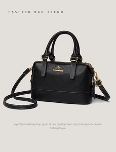 Detail of black Boston handbag featuring golden hardware and adjustable leather strap