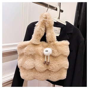 Detailed view of camel faux fur bucket bag with wavy texture and plush doll charm