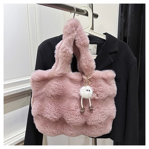 Pink plush bucket bag detail featuring fluffy faux fur and a cute monster charm on a hanger
