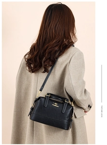 Classic black leather Boston bag with gold logo shown on model for size and style guide