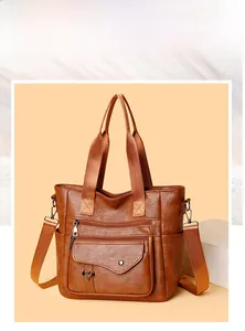 Close-up of brown faux leather tote bag featuring multi-zipper pockets and heart charm