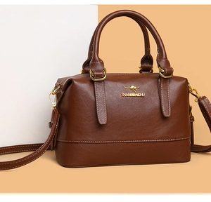Detail of golden kangaroo logo and brand lettering on brown leather Boston bag
