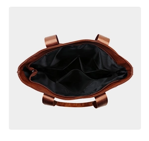 Detailed interior of caramel brown PU tote bag with multiple storage pockets and zipper