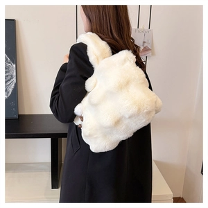 Detail of soft white faux fur backpack showing plush texture against a black suit