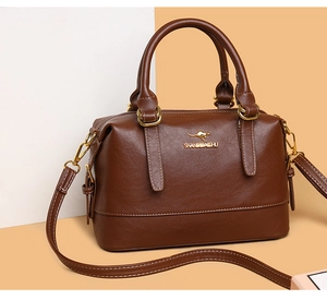 Close-up of brown faux leather Boston bag featuring gold metal hooks and embossed brand logo
