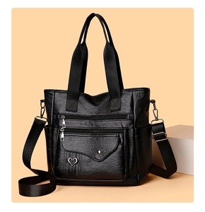 Detail view of black PU leather tote bag with functional zippers and heart buckle pocket