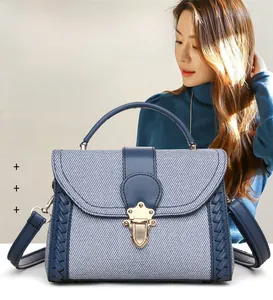 Detail view of woven fabric and navy leather trim on a large capacity shoulder bag