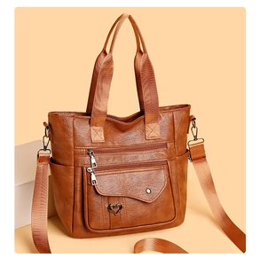 Close-up of brown PU leather tote bag featuring multiple zipper pockets and heart detail