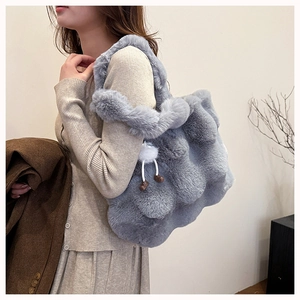 Close-up of grey plush faux fur tote bag with a cute white pom-pom charm detail