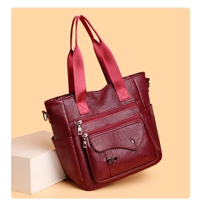 Detail view of burgundy tote bag showing textured PU leather and heart metal buckle