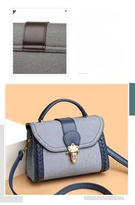 Detail of blue striped fabric bag with navy leather flap and vintage gold twist lock