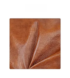 Close-up of high-quality brown PU leather with natural pebble grain texture on a tote bag