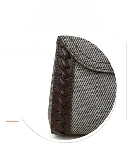 Detail of woven texture canvas and handcrafted leather braid on stylish handbag