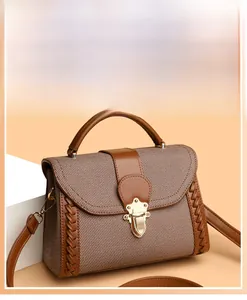 Close-up of brown woven fabric handbag with leather trim and vintage gold metal lock