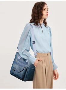 Macro shot of large navy PU leather tote bag with functional zippers and stylish woven strap