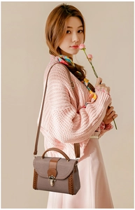 Brown vintage textured satchel bag shown with pink knit cardigan and long dress