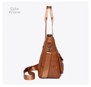 Side view of large brown soft PU leather tote bag showing shoulder strap and metal hooks