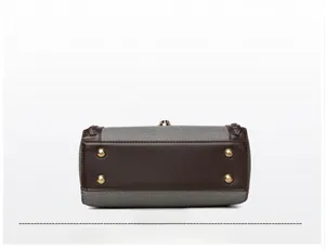 Detailed view of bag base with golden protective studs and brown leather texture